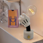 Clérachic novelty table lamp on a white marble base beside a pink gift box printed with a heart-shaped hand graphic.