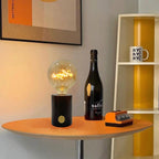 Clérachic novelty table lamp lit on a round orange table beside a wine bottle and a printed mug.