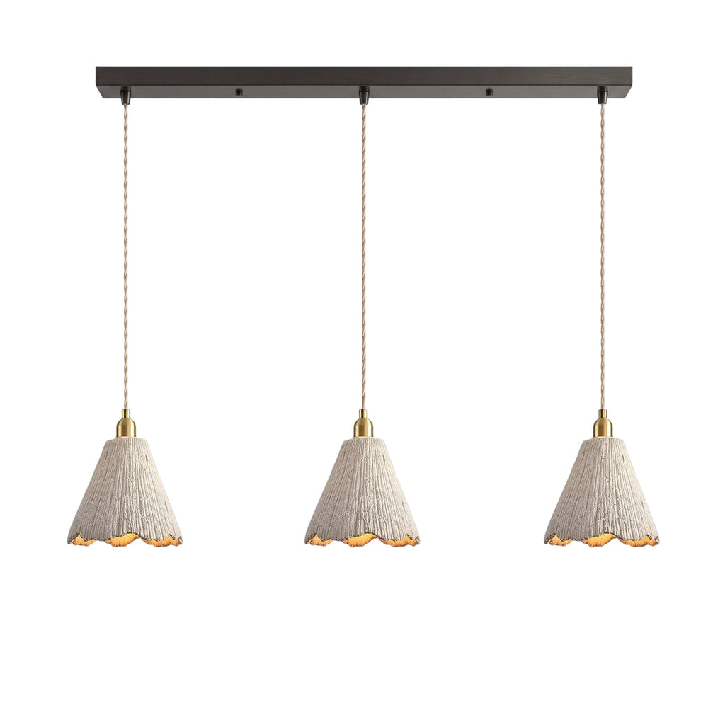 Three tall scalloped cone microcement pendants hung in a row from a dark linear ceiling canopy on braided cords
