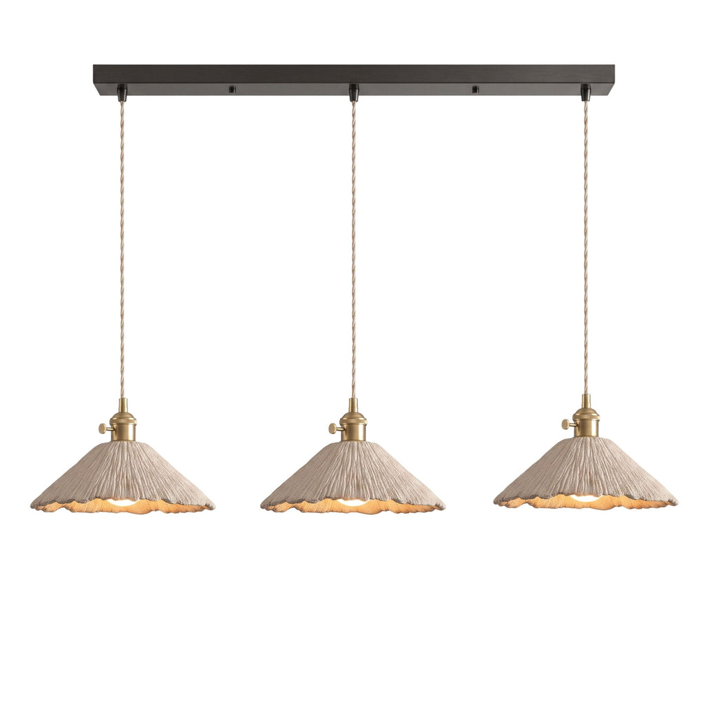 Three wide scalloped cone microcement pendants hung in a row from a dark linear ceiling canopy on braided cords