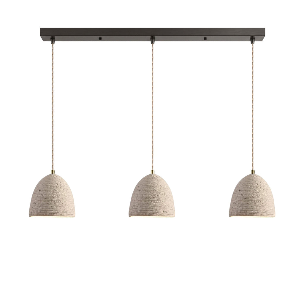 Three small bell dome microcement pendants hung in a row from a dark linear ceiling canopy on braided cords