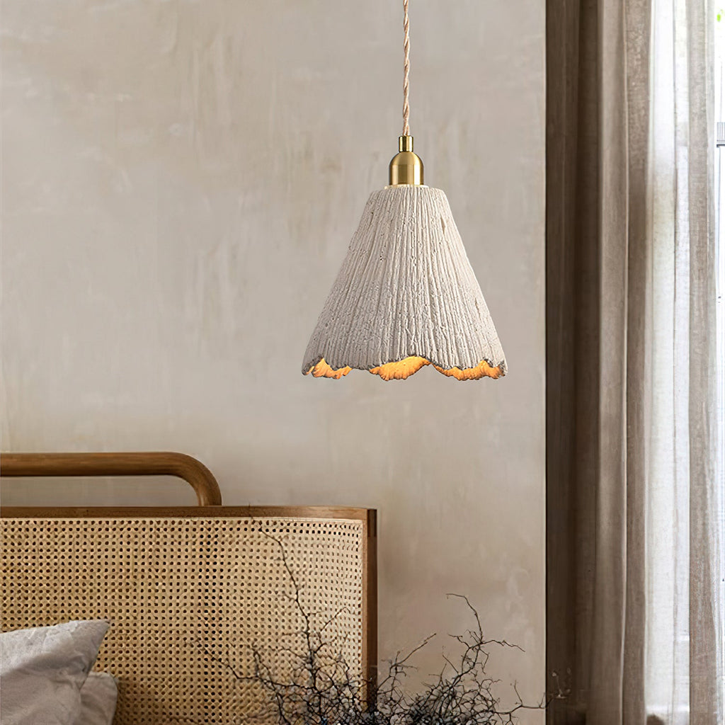 Raw cement pendant light glowing in a warm room