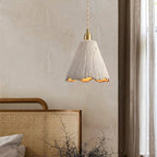 Raw cement pendant light glowing in a warm room