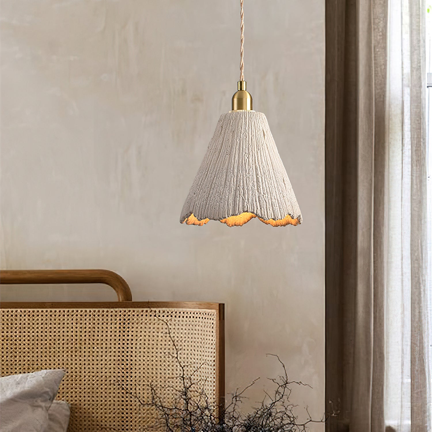 Raw cement pendant light glowing in a warm room