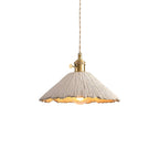 Cement pendant light glowing warmly from a braided cord