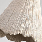 Microcement pendant light glowing softly in a styled room
