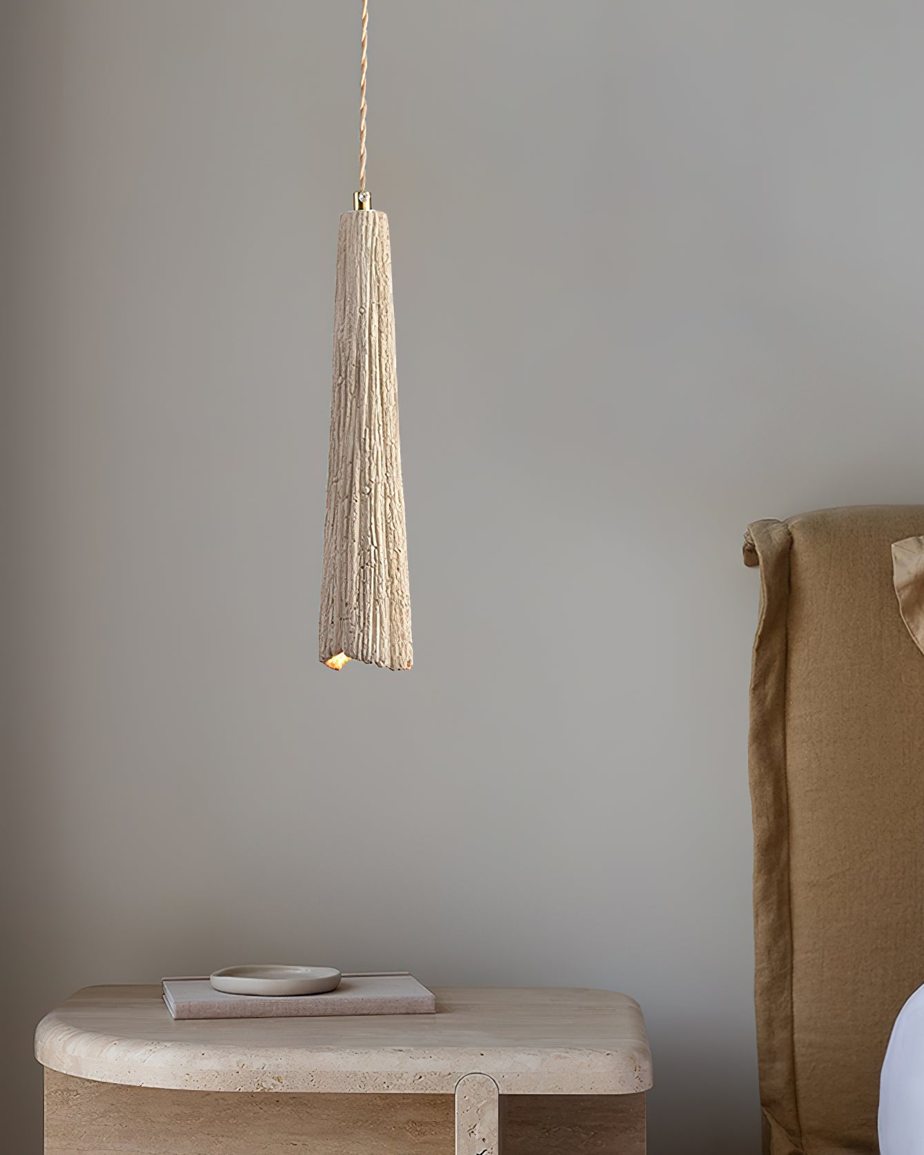 Cement pendant light shown lit against a dark backdrop