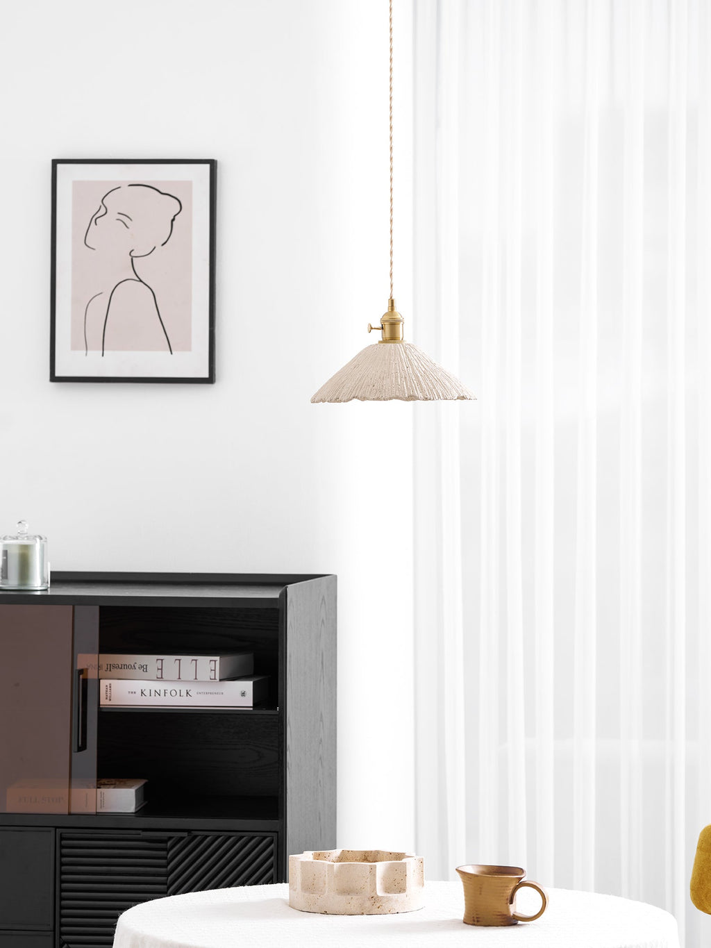 Disc shaped microcement pendant light shown lit warmly