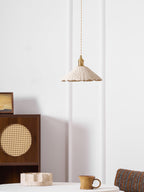 Wide disc microcement pendant light hanging over a table