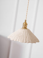 Flat disc cement pendant light glowing warm below
