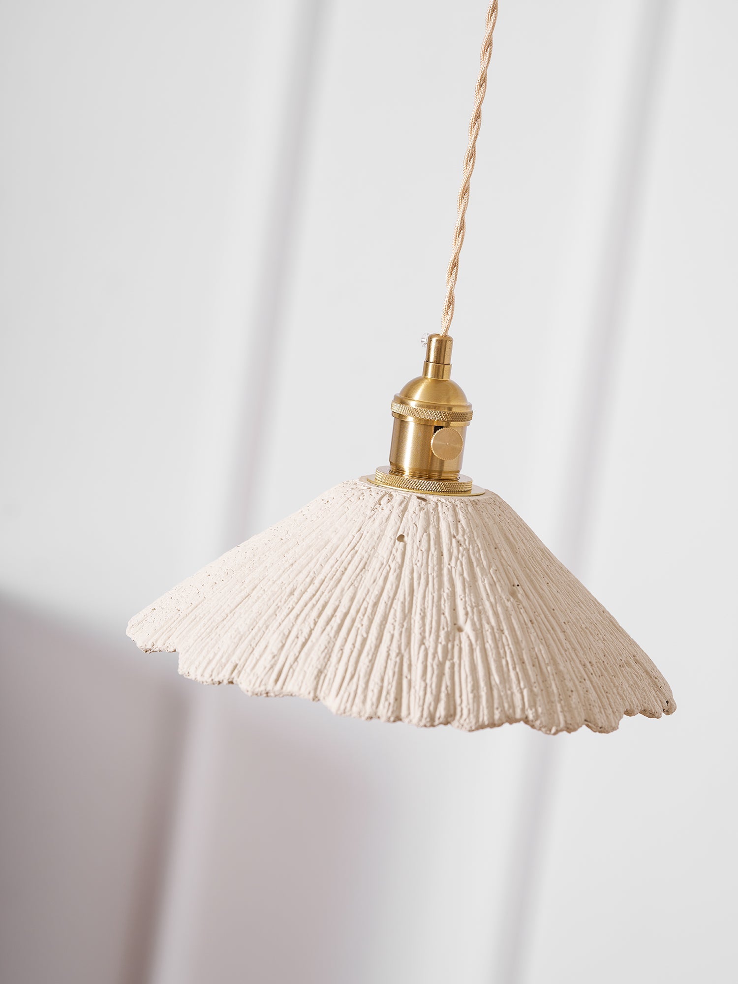 Flat disc cement pendant light glowing warm below