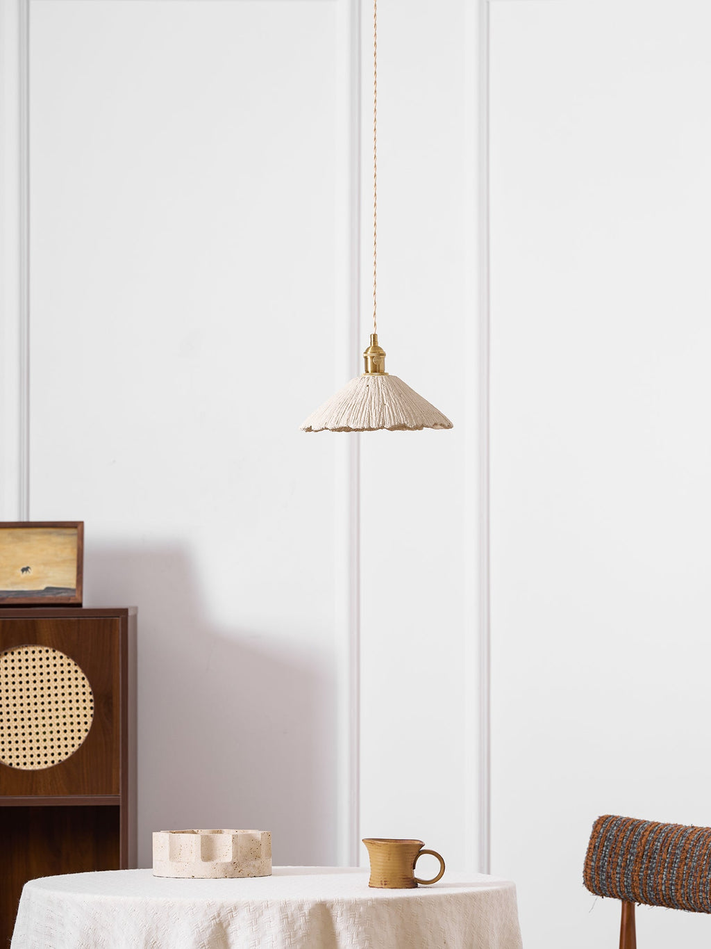 Wide disc microcement pendant light shown in an interior