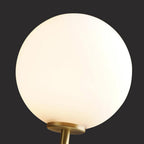 Close view of the round white glass globe on this Clérachic wall light, set against a dark background.