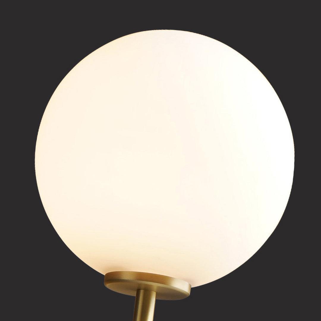 Close view of the round white glass globe on this Clérachic wall light, set against a dark background.