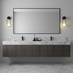 Black-finish Clérachic wall lights flank a rectangular mirror above a marble bathroom vanity with dark wood cabinetry.