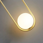 Dramatic low-angle close-up of this brass Clérachic wall light, its oval frame curving around a glowing opal glass globe.