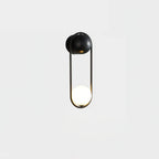 A black-finish Clérachic wall light on a plain white background, its opal glass globe glowing at the base of the loop.