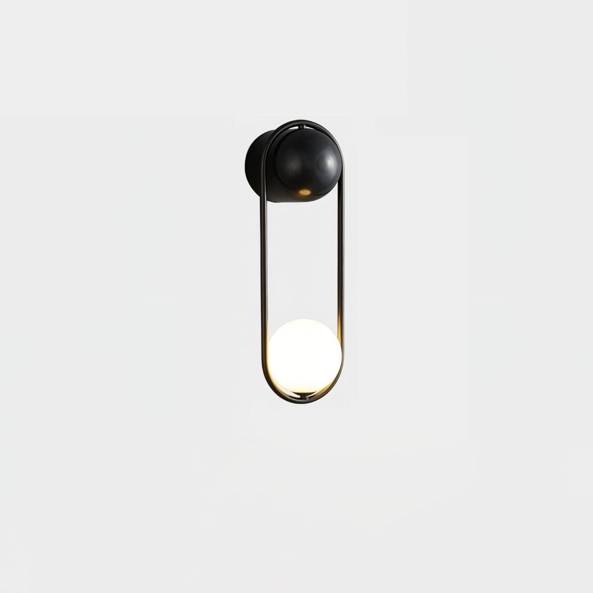 A black-finish Clérachic wall light on a plain white background, its opal glass globe glowing at the base of the loop.