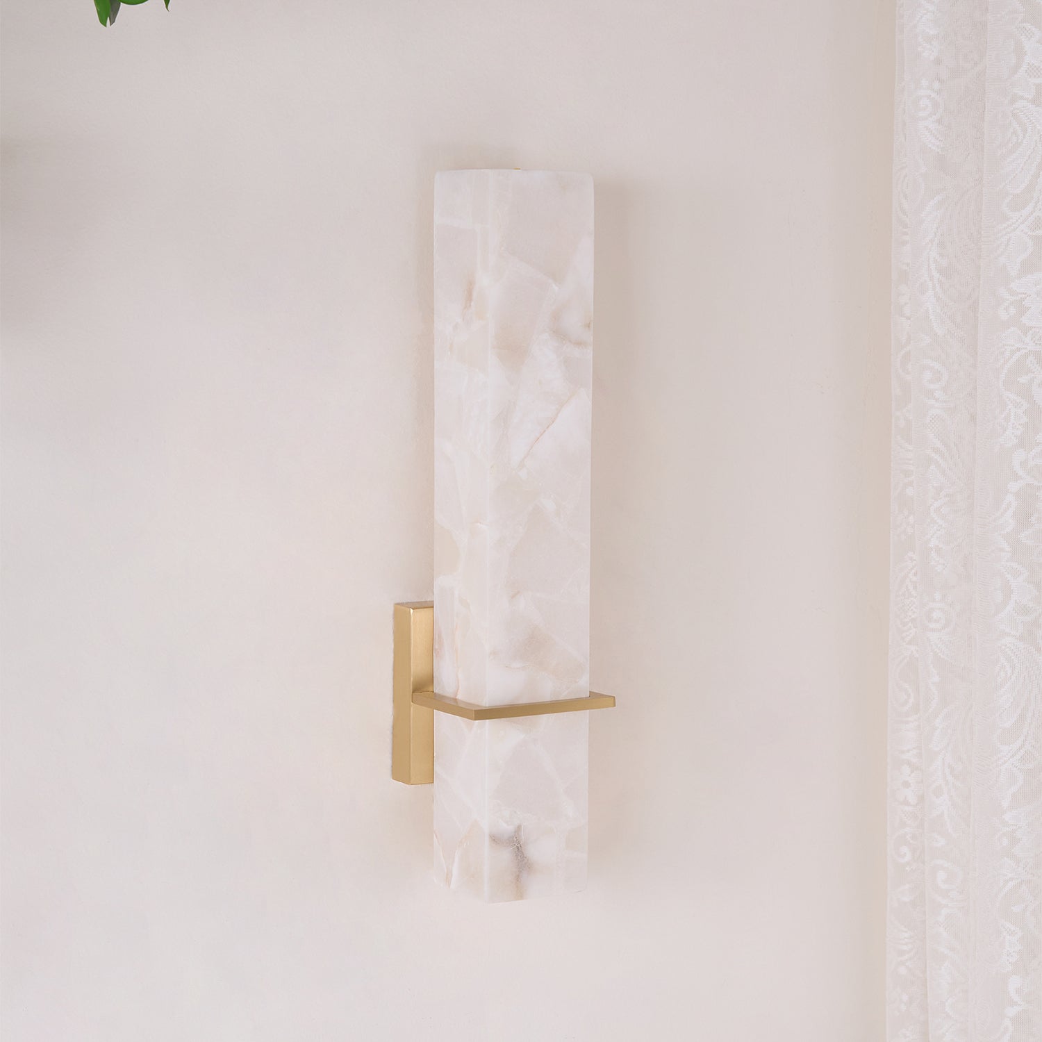 Angled view of the unlit fixture showing the depth of the cuboid and its brass wall plate