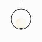 Glass ball pendant light glowing warm in a styled room