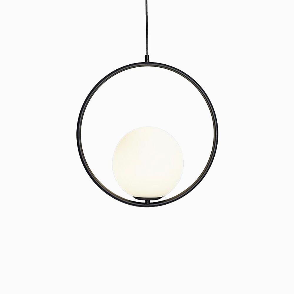 Glass ball pendant light glowing warm in a styled room