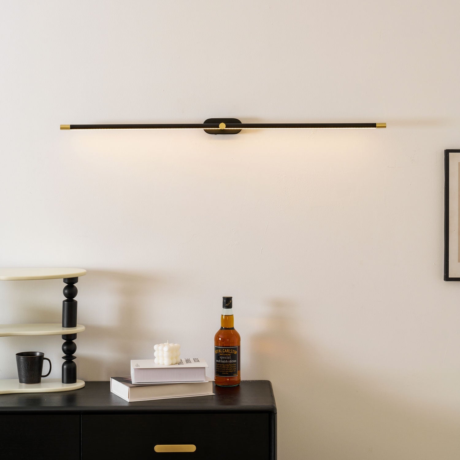 Slim linear wall lamp glowing warm in a styled room