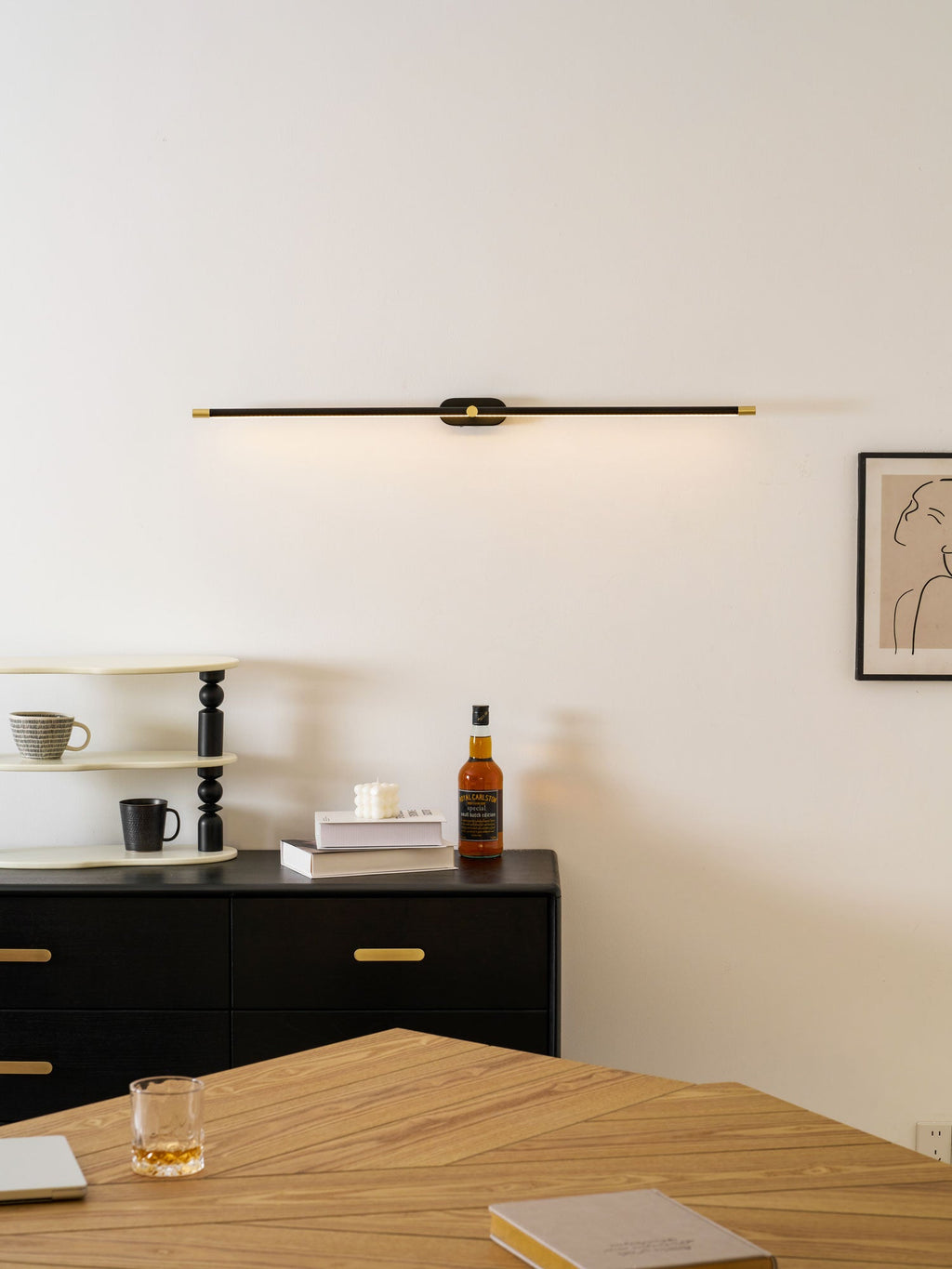 Cordless linear wall lamp mounted above a bathroom mirror