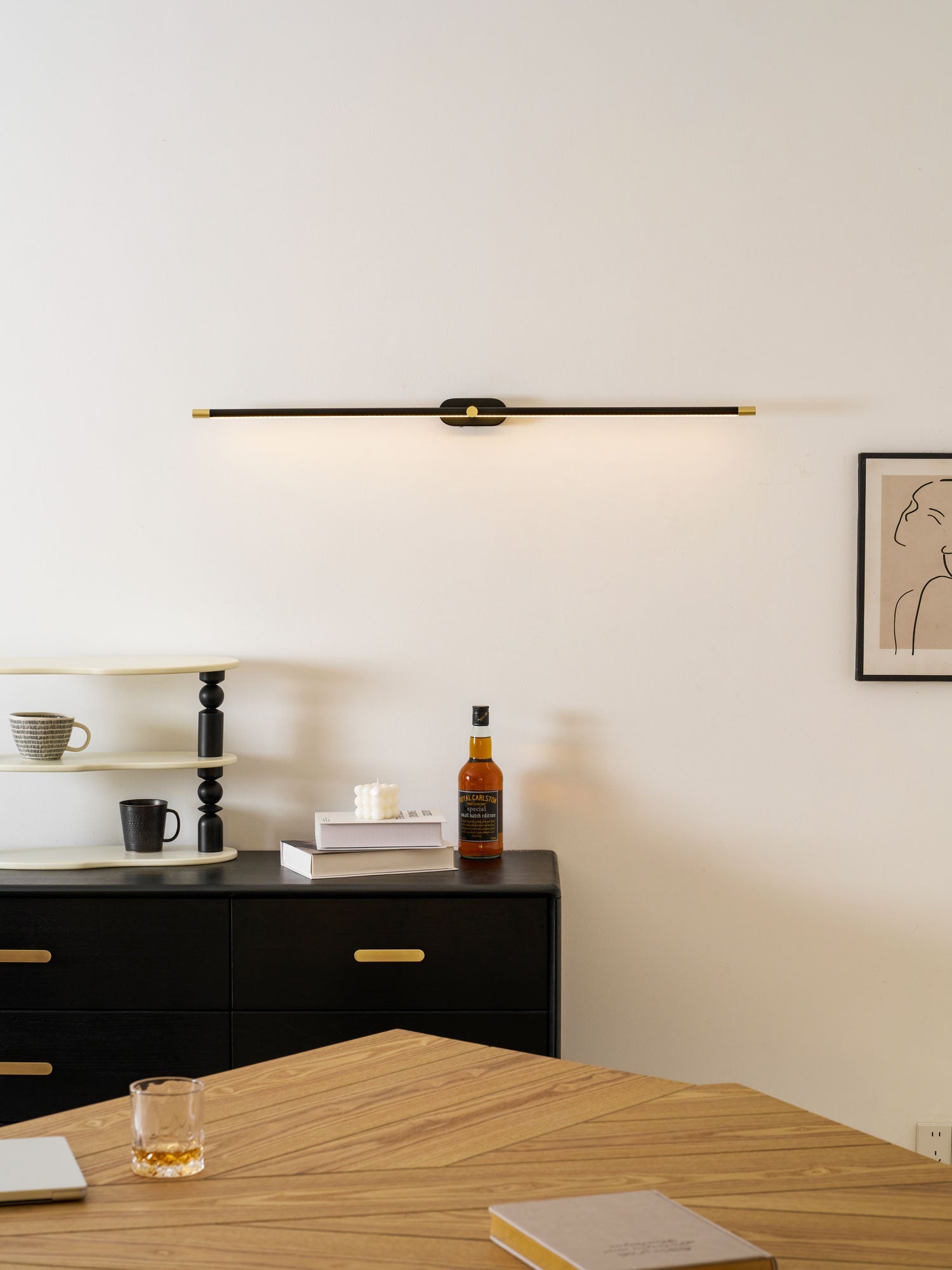 Cordless linear wall lamp mounted above a bathroom mirror