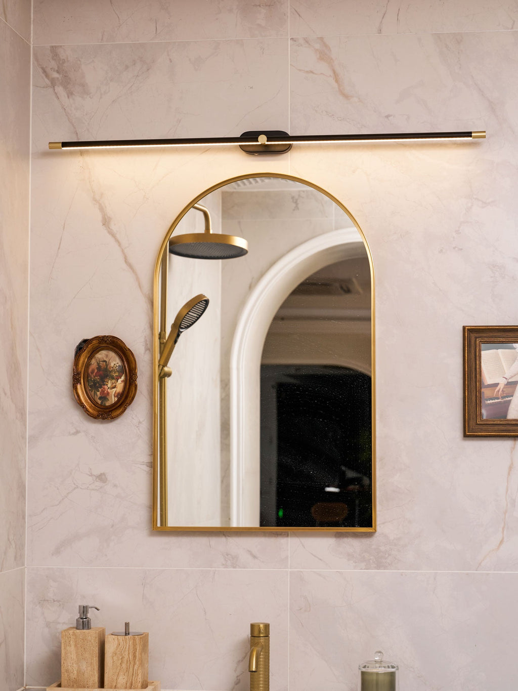 Slim linear wall lamp casting warm light in a dressing area