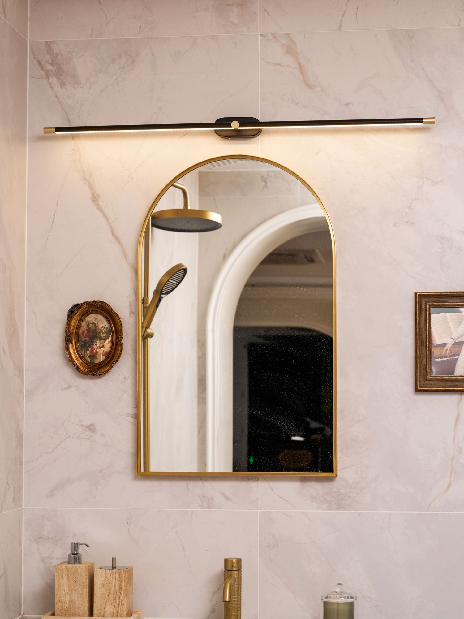 Slim linear wall lamp casting warm light in a dressing area