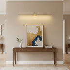Minimalist linear wall lamp above a mirror in a bathroom