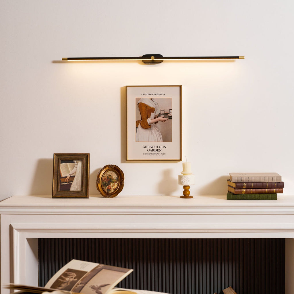Minimalist linear wall lamp glowing beside a framed mirror