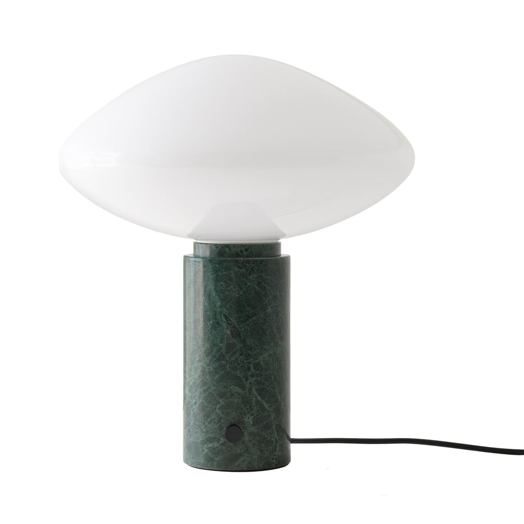 Clérachic table lamp lit against a pale backdrop, cropped to the oval shade with its green marble column below.