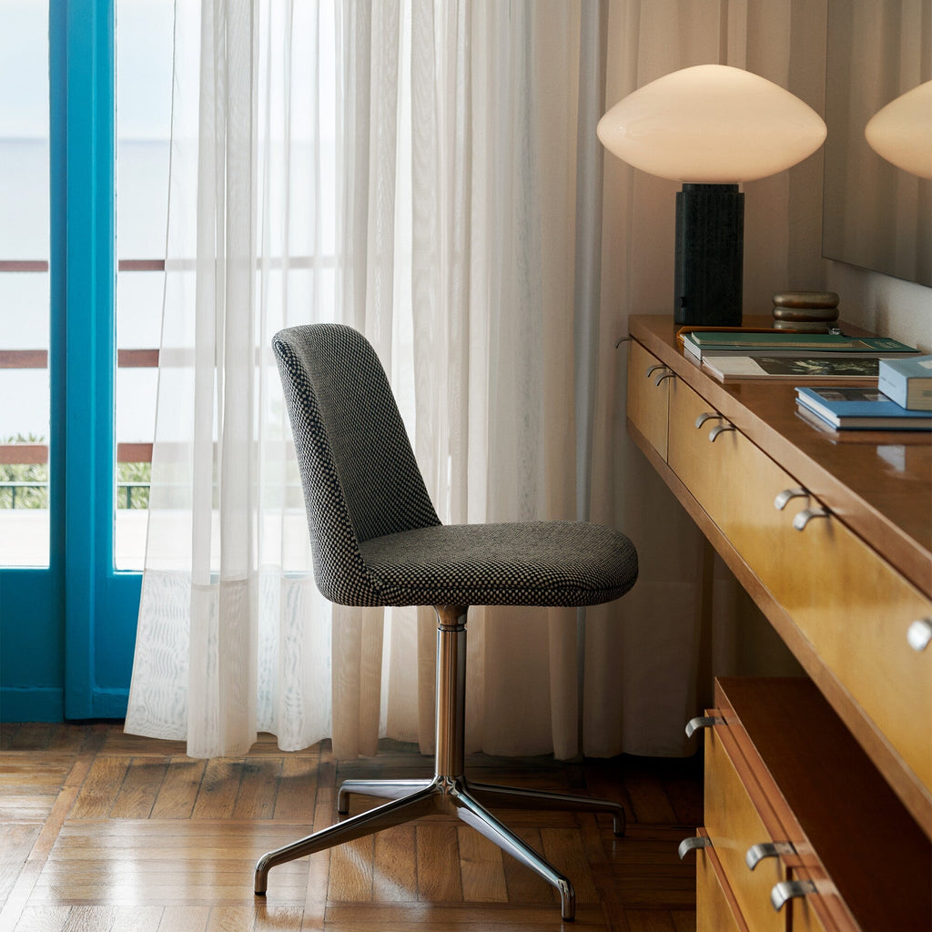 Clérachic marble table lamp lit on a distant sideboard, seen past an office chair by a window with sheer curtains.