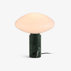 Clérachic green marble table lamp switched off on a plain backdrop, its oval frosted shade and trailing cord fully in view.