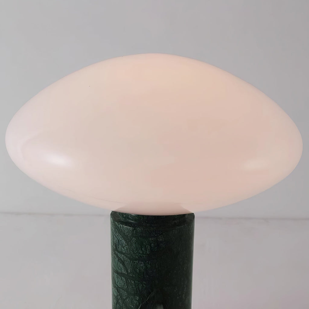 Clérachic table lamp shown in close-up, the frosted shade's underside meeting the green marble column below.