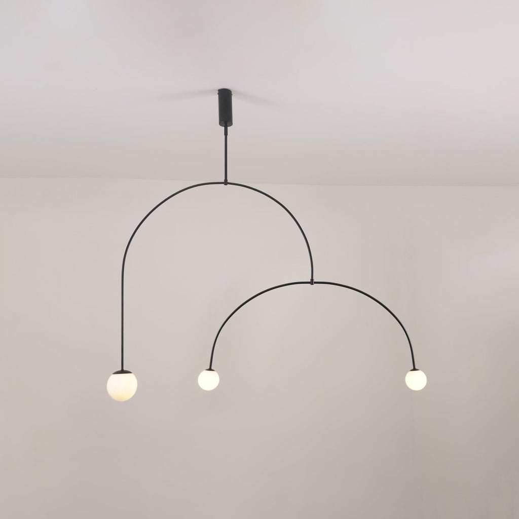 Mobile chandelier shown lit with soft ambient glass globes