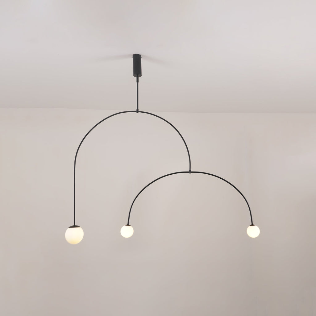 Graphic chandelier with opaline globes along clean brass lines