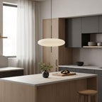 Disc pendant light shown over a kitchen island