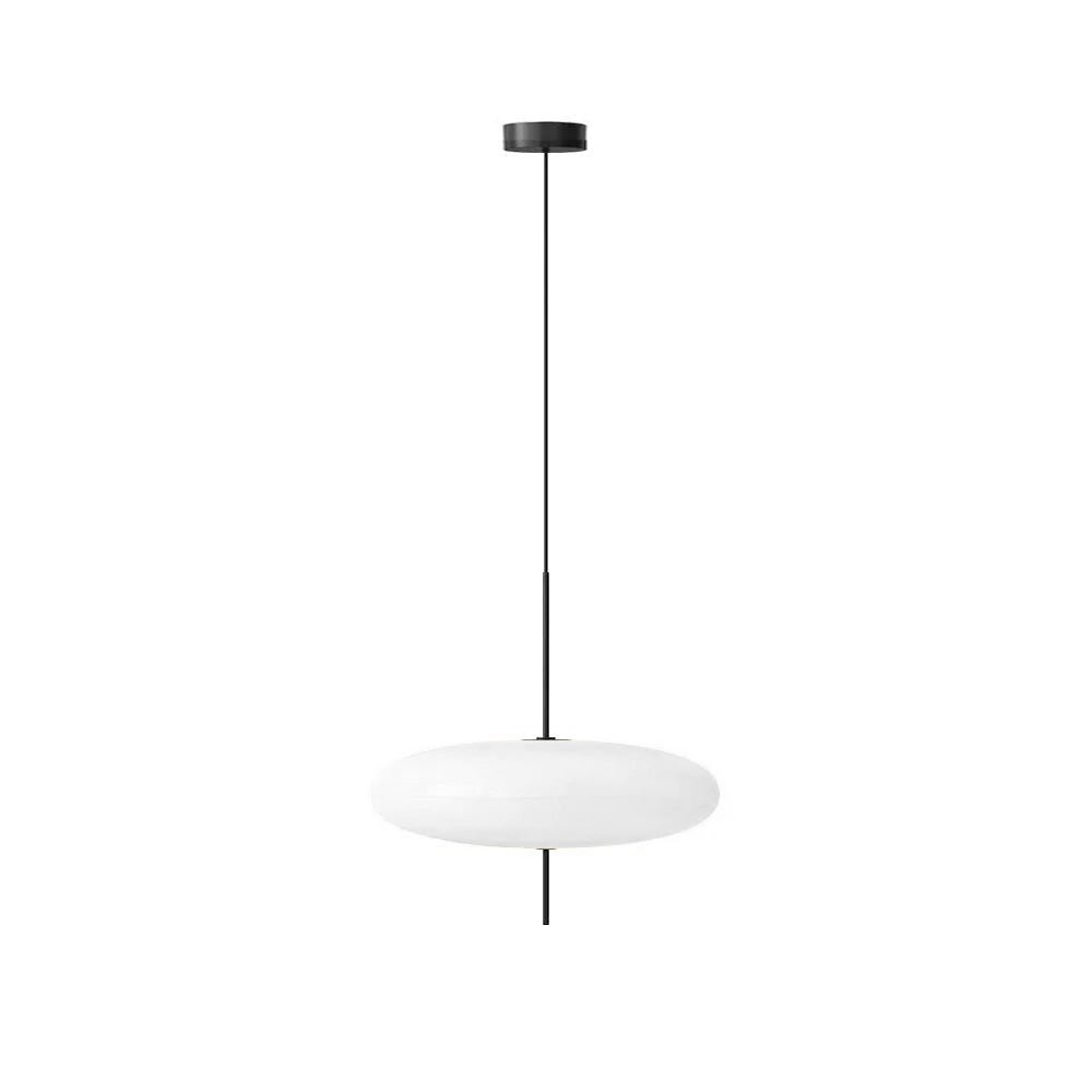 Opalescent disc pendant light glowing softly over a table