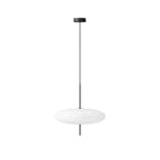 Opalescent disc pendant light glowing softly over a table