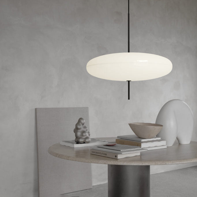 Disc pendant light casting even light over a table