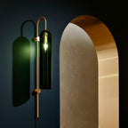 glass wall lamp mounted beside artwork in a styled interior