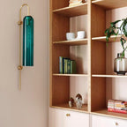 Modern glass wall lamp styled against a textured wall