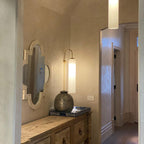 Modern glass wall lamp shown lit in an interior setting