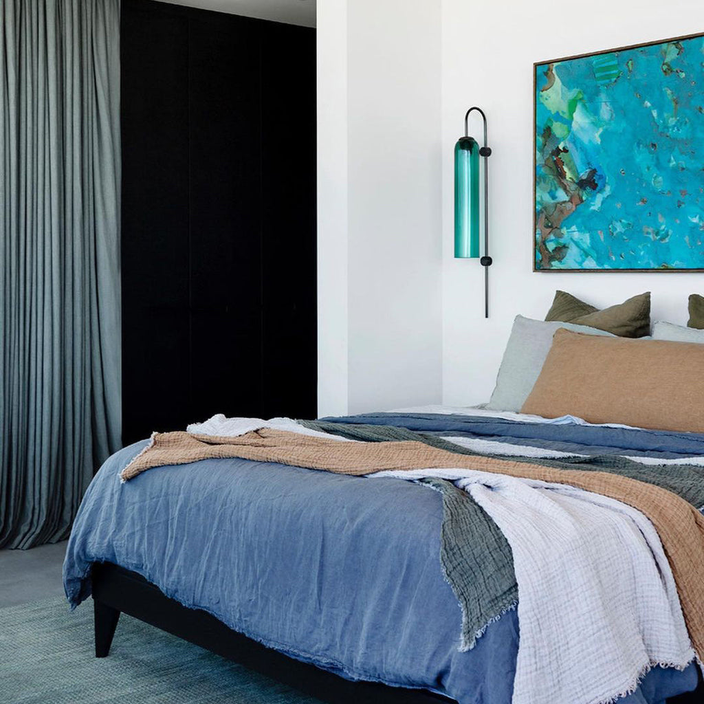 Modern glass wall lamp styled against a painted wall