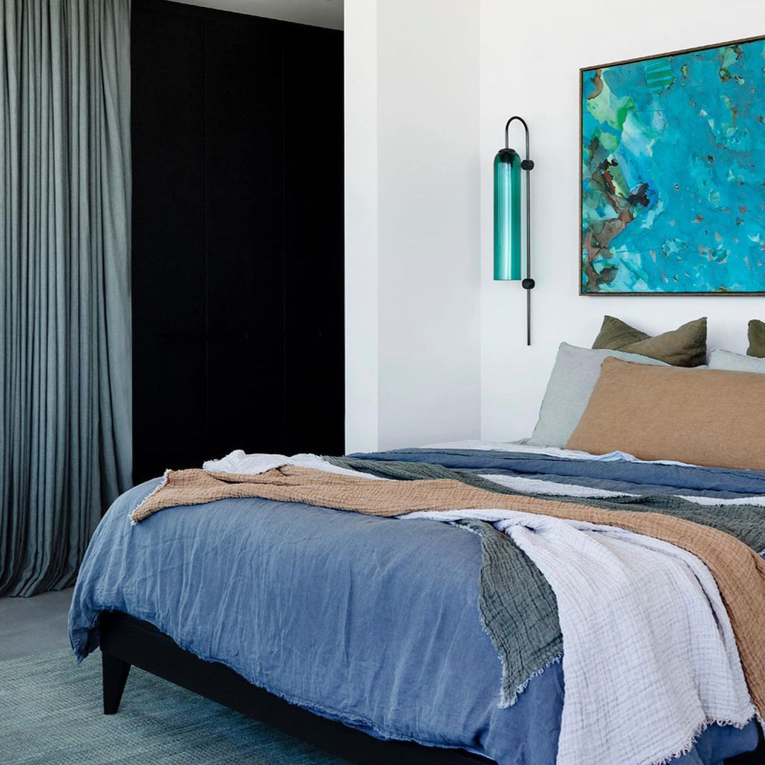 Modern glass wall lamp styled against a painted wall