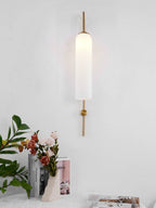 Modern glass wall lamp shown lit against a dark wall
