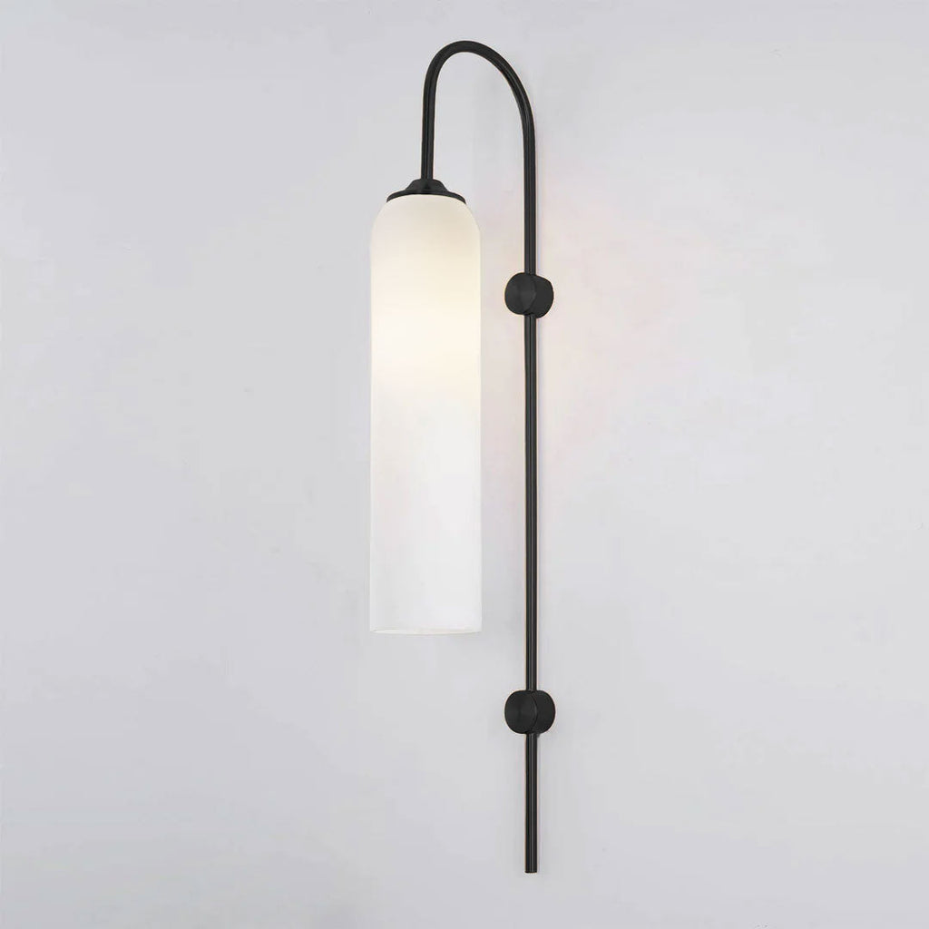 Modern glass wall lamp shown lit with a warm cylinder glow