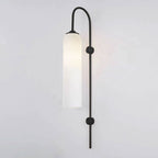 Modern glass wall lamp shown lit with a warm cylinder glow